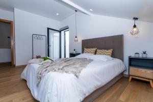 a bedroom with a large white bed with white sheets at Carvão Pdl Inn in Arrifes