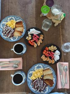 a table with plates of breakfast food on it at Amy's room in Bluefields