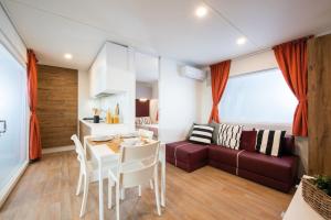 a kitchen and a living room with a table and a couch at Vigna sul Mar Family Camping Village in Lido di Pomposa