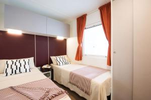 a bedroom with two beds and a window at Vigna sul Mar Family Camping Village in Lido di Pomposa