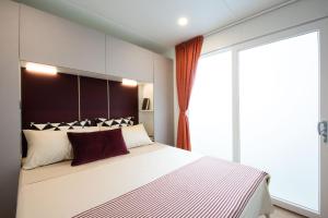ein Schlafzimmer mit einem großen Bett und einem großen Fenster in der Unterkunft Vigna sul Mar Family Camping Village in Lido di Pomposa