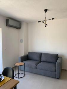 a living room with a blue couch and a table at Sea View Apartment - first row to the beach in Zubovići