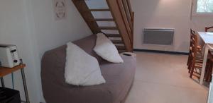 a couch with two pillows on it in a living room at Montagne Ariégeoise in Aulus-les-Bains
