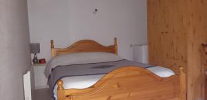 a bedroom with a wooden bed in a room at Montagne Ariégeoise in Aulus-les-Bains
