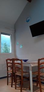 a dining room with a table and chairs and a window at Montagne Ariégeoise in Aulus-les-Bains