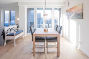 a dining room with a wooden table and chairs at Verpuusten in Husum