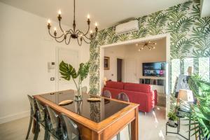 comedor con mesa y sofá rojo en AwesHomeItaly - White Mirrors Apartment, en Pisa