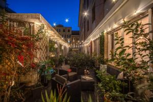an outdoor patio with plants and lights at night at AwesHomeItaly - White Mirrors Apartment in Pisa