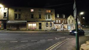 a car driving down a city street at night at Stylish Town Centre Apartments in Nailsworth