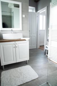 ein Badezimmer mit einem weißen Waschbecken und einem Spiegel in der Unterkunft Apartment Brina in Hum na Sutli