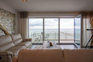 - un salon avec un canapé et une vue sur l'océan dans l'établissement Haus-Zur-Mole-Wohnung-8-Leonardo, à Großenbrode