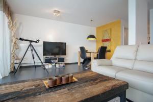 - un salon avec un canapé et une table avec une caméra dans l'établissement Haus-Zur-Mole-Wohnung-8-Leonardo, à Großenbrode