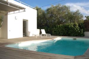 una piscina con una sedia accanto a una casa di Villa avec piscine & jardin à Monticello a Monticello