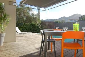 un patio con tavolo e sedie su un ponte di Villa avec piscine & jardin à Monticello a Monticello