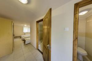 uma casa de banho com WC e uma porta para um quarto em Strand Motel, Vígadó Csárda em Dombrád