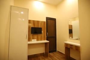 a bathroom with a television and a door with a mirror at The Park View Hotel in Amritsar +44 photos