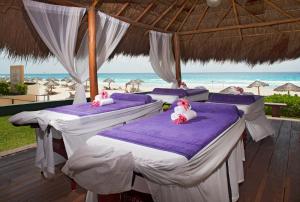 a group of four beds in a pavilion at the beach at Emporio Cancun - Buy All Inclusive Option in Cancún