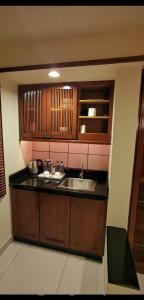 a kitchen with a sink and wooden cabinets at Water Chalet or Premium Tower Seaview Port Dickson , Private Room in Port Dickson
