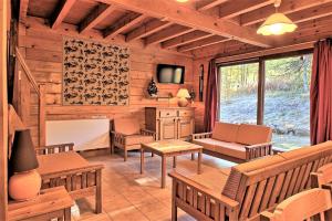 a log cabin living room with wooden furniture and a large window at CASA Les Heureux Magnifique CHALET 6 chambres à RISOUL in Risoul