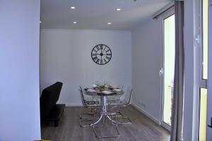 une salle à manger avec une table et une horloge murale dans l'établissement Apartamento DAVI, à Funchal