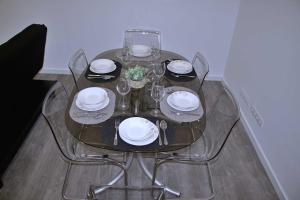a glass table with plates and glasses on it at Apartamento DAVI in Funchal