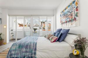 Un dormitorio con una cama grande con almohadas. en Pop Art, Apartamento de Diseño en Arenal 303, en Sevilla