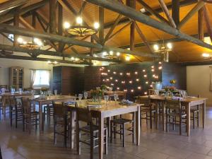 Un comedor con mesas y sillas de madera y luces. en Villa Flor Ecoresort, en Nova Petrópolis