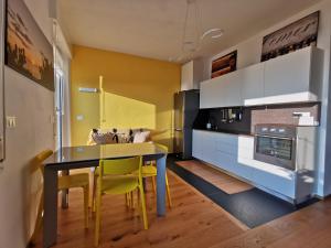 a kitchen with a dining table and yellow chairs at Blue Nest in Genoa