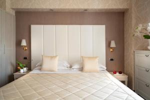 a bedroom with a large bed with white pillows at Boutique Hotel Re Enzo in Bologna