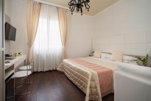 1 dormitorio con cama, escritorio y ventana en Boutique Hotel Re Enzo en Bolonia