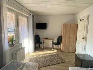 a bedroom with a bed and a desk and a television at Privatzimmer Hoffmann in Kaltenborn