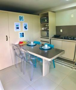 a kitchen with a table and two chairs and a kitchen with a table and chairs at ALIANÇA TABATINGA Hospedagem Boutique in Conde