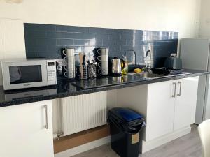 encimera de cocina con microondas y fregadero en Southbank Guesthouse en Elgin
