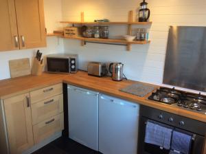 a kitchen with a counter with a stove top oven at Lovely Victorian town house close to the sea. in Bangor