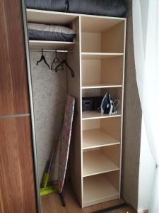 a closet with a book shelf and a bed at Pie jūras in Liepāja