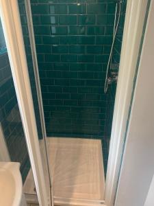 a bathroom with a shower with green tiles at The Farmers Boy Inn Guest House in Longhope +44 photos