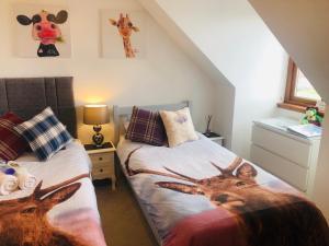 a bedroom with two beds with deer heads on them at Inverness Holiday House - 2 Bedroom in Inverness