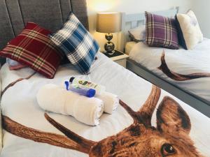una camera da letto con un letto con una testa di cervo sopra di Inverness Holiday House - 2 Bedroom a Inverness