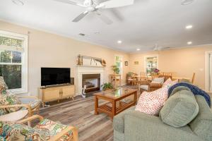 a living room with a couch and a tv at Anchors Away in Folly Beach