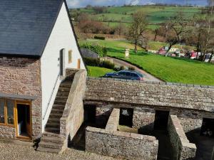a stone bridge next to a building with a car at Captains Lookout (Studio apartment) in Brecon