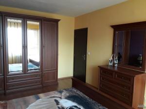 een slaapkamer met een bed, een dressoir en een spiegel bij Апартамент Орхид Хилс in Varna