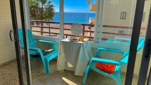einen Tisch und Stühle auf einem Balkon mit Blick auf den Strand in der Unterkunft Liberty 4 personas Calpe centro in Calpe