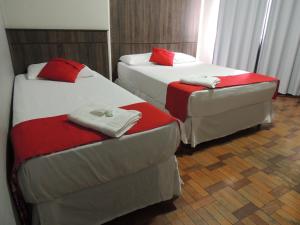 duas camas e uma cadeira num quarto em Hotel Gontijo Belo Horizonte - Próximo a Rodoviária e Praça Sete em Belo Horizonte