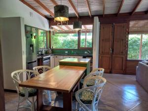 a kitchen with a wooden table and chairs at Las Cortaderas Bosque Peralta Ramos in Mar del Plata
