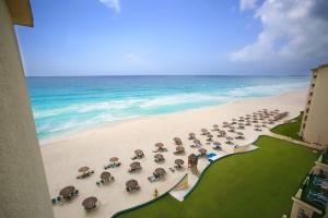 a beach with a lot of umbrellas on it at The Royal Islander – An All Suites Resort in Cancún