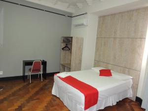 1 dormitorio con 1 cama, 1 silla y chimenea en Hotel Gontijo Belo Horizonte - Próximo a Rodoviária e Praça Sete, en Belo Horizonte