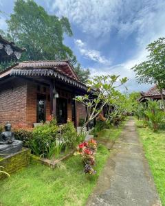 a brick house with a garden in front of it at Ndalem Setumbu in Magelang