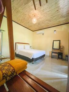 Schlafzimmer mit einem Bett und einem Spiegel in der Unterkunft Ndalem Setumbu in Magelang