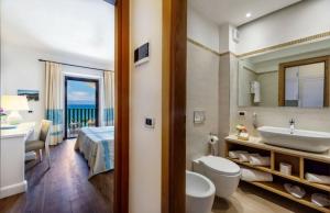 
a bathroom with a toilet, sink, and bathtub at Hotel Dei Pini in Fertilia
