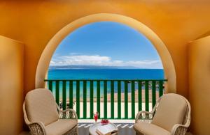 a balcony with two chairs and a view of the ocean at Hotel Dei Pini in Alghero